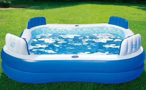 Blue inflatable pool filled with water and placed on the green grass yard.