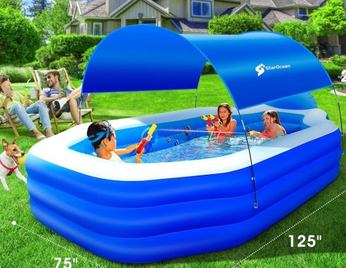 A family enjoys a sunny day in their backyard, with children playing in a large, blue inflatable pool with a canopy while the parents relax nearby on lawn chairs.