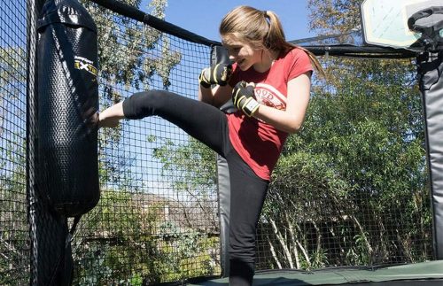 The girl kicking the training bag in the trampoline