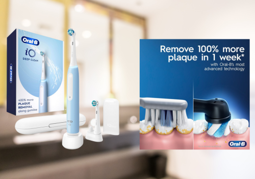The image displays the Oral-B iO Series electric toothbrush in a softly blurred bathroom setting. On the left, the blue retail box advertises "DEEP CLEAN" and "400% more PLAQUE REMOVAL along gumline," accompanied by the light blue toothbrush on its white charging base, a white travel case, and an extra brush head with a stand. To the right, a promotional close-up illustrates the toothbrush removing plaque, with text claiming "Remove 100% more plaque in 1 week* with Oral-B's most advanced technology," and the Oral-B logo is visible.